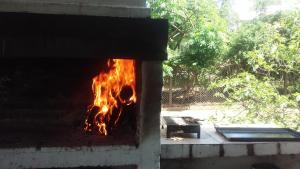 a brick oven with a fire in it at Hospedaje Casa Azul in Villa Allende