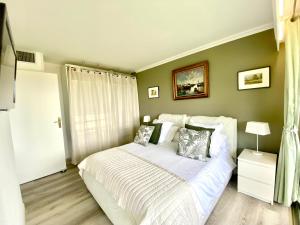 een slaapkamer met een bed met witte lakens en kussens bij Eden Barmassa in Villefranche-sur-Mer