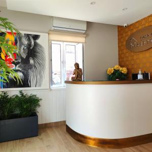 a woman standing at the counter of a waiting room at Casa do Maestro in Portomarin