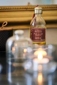 a bottle of oil sitting on a table with a candle at Riad Rafaele & SPA in Marrakesh