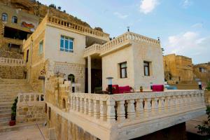 a house with a balcony with red chairs on it at Kasri Reyyan in Mardin