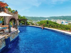 una pareja en una piscina en un complejo en Casa Lisa, en Acapulco
