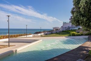 a swimming pool with the ocean in the background at Downtown & Beach in Albufeira