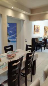 a dining room with a table and chairs and a piano at Villa Katerina in Ialysos +38 photos