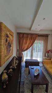 a living room with a table and a couch at Villa Katerina in Ialyssos