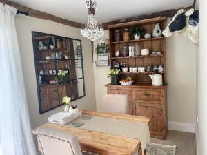 a dining room with a table and a chandelier at Church Farm in Thurlton