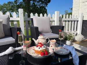 a table with a tea set with a cake and strawberries at Church Farm in Thurlton