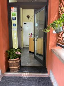 an open door of a building with potted plants at Hotel degli Dei in Pianoro