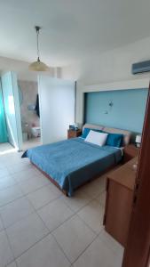a bedroom with a bed with a blue comforter at Villa Katerina in Ialyssos