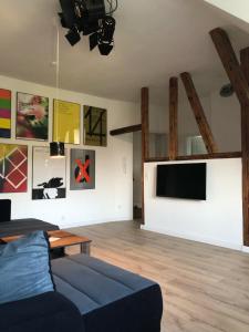 a living room with a couch and a flat screen tv at stay at Randolphs in Kassel