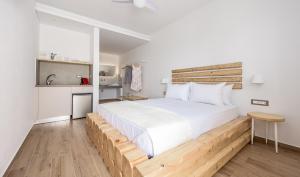 a bedroom with a large white bed with a wooden headboard at Annarita in Adamantas