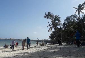 eine Gruppe von Menschen, die am Strand spazieren in der Unterkunft Serene 2 bedroom homestay 15mindrive to the beach in Mombasa