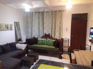 ein Wohnzimmer mit einem Sofa und einem TV in der Unterkunft Serene 2 bedroom homestay 15mindrive to the beach in Mombasa