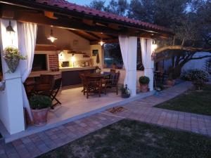 a patio with a table and chairs under a pergola at Apartments LEON 2 in Rab