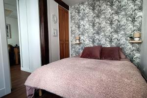 um quarto com uma cama com papel de parede floral em Logement dans maison de pêcheur em Le Tréport