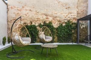 2 sillas y una mesa en un jardín en r12 Apartments, en Győr