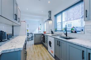 a large kitchen with a sink and a dishwasher at Spacious 4-bed house in Crewe by 53 Degrees Property, ideal for Business & Contractors, Great Location - Sleeps 8 in Crewe
