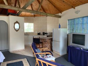 a kitchen with a refrigerator and a table with a tv at Brackenburn Trout and Trail Retreat in Elandskop