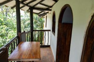 einen Holztisch auf der Veranda eines Hauses in der Unterkunft El Refugio Hostel Curití in Curití