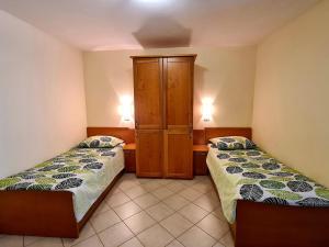 een slaapkamer met 2 bedden en een kast erin bij Guest house Kočanija in Ilirska Bistrica