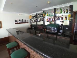 a bar with a counter with bottles on the wall at Hotel Trindade Coelho in Mogadouro