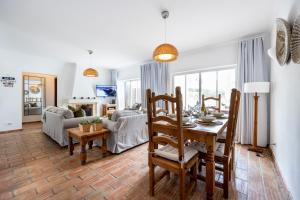 cocina y sala de estar con mesa y sillas en CoolHouses Luz, 3 Bed linked house, shared pool, a stone's throw of the sea, Casa Sirrah en Luz