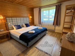 ein Schlafzimmer mit einem großen Bett mit blauen Kissen und einem Fenster in der Unterkunft Ferienwohnung an der Familienabfahrt in Brixen im Thale