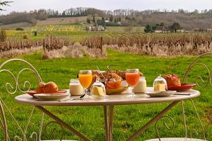 een tafel met een ontbijt van jus d'orange en croissants bij Clair de Vigne in Monbazillac