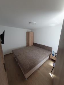 a bedroom with a bed in the corner of a room at Napfény Vendégház in Vonyarcvashegy