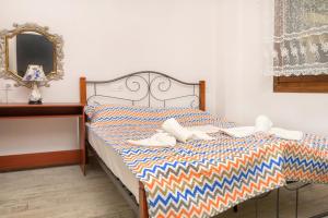 a bed with towels on it with a mirror at DANAI HOUSE 3 in Nea Roda +3 photos