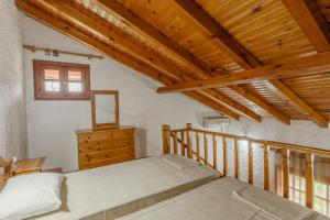 a bedroom with a bed and a wooden ceiling at Sophia's maisonette 1 in Stoupa