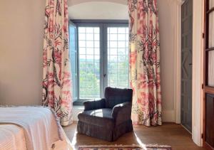 um quarto com uma cadeira e uma janela em Castillo de Corvinos em Huesca