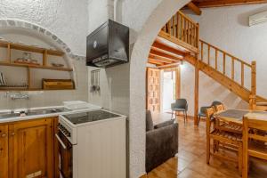 a kitchen with a stove and a dining room with a table at Sophia's maisonette 1 in Stoupa