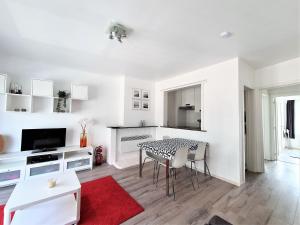 ein weißes Wohnzimmer mit Tisch und Stühlen in der Unterkunft Appartement 2 chambres 200m plage Nieuwpoort Bad in Nieuwpoort