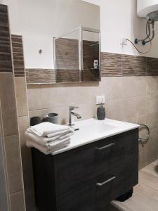 een badkamer met een wastafel en een spiegel bij Camurría Sicily home in Montelepre