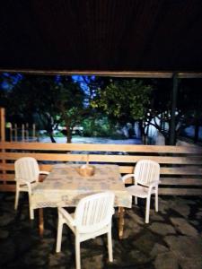 沃洛斯的住宿－Volos Traditional beach House 2，一张木桌和两把白色椅子、一张桌子和一张椅子