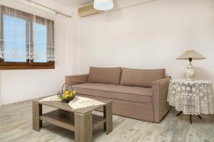 a living room with a couch and a table at DANAI HOUSE 3 in Nea Roda
