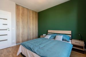 una camera da letto con pareti verdi e un letto con lenzuola blu di Luxury in City -5- Free Parking a Łódź