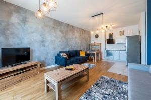 uma sala de estar com um sofá azul e uma televisão em Luxury in City -5- Free Parking em Lódź