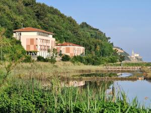 a building on a hill next to a body of water at Hotel Oleander - Oleander Resort in Strunjan