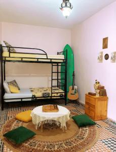 a room with two bunk beds and a table at Vibe Surf Morocco in Agadir