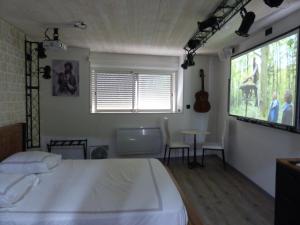 een slaapkamer met een bed, een tafel en een raam bij MAURY CAT'STUDIO 66 in Maury