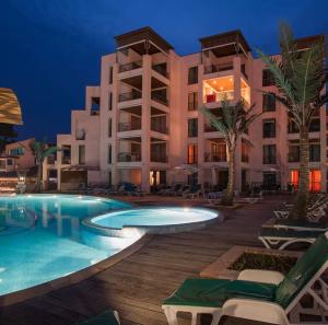 a resort with a swimming pool at night at Marina City ApartHotel in Balchik
