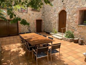 einen Holztisch und Stühle auf einer Terrasse in der Unterkunft Masía Can Janet in Arbúcies