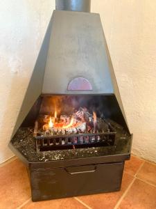 uma churrasqueira com chamas num quarto em Rondebossie Farm Retreat em Magoebaskloof