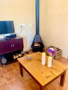 sala de estar con mesa de madera y chimenea en Rondebossie Farm Retreat en Magoebaskloof