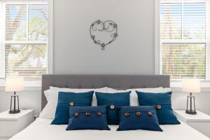 a bedroom with a bed with blue pillows and a heart plaque at Stonewall House in St. Augustine