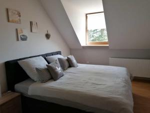 a bedroom with a large white bed with a window at Knoofs in Schwirzheim