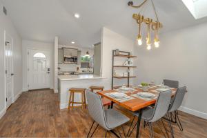 a dining room and kitchen with a table and chairs at Unique Balinese Home with Fire Pit and Private Fenced Yard! 30 Seconds to the Sand! in New Smyrna Beach