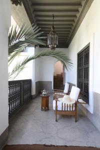 a patio with a table and chairs and a chandelier at Riad Zaouia 44 in Marrakesh